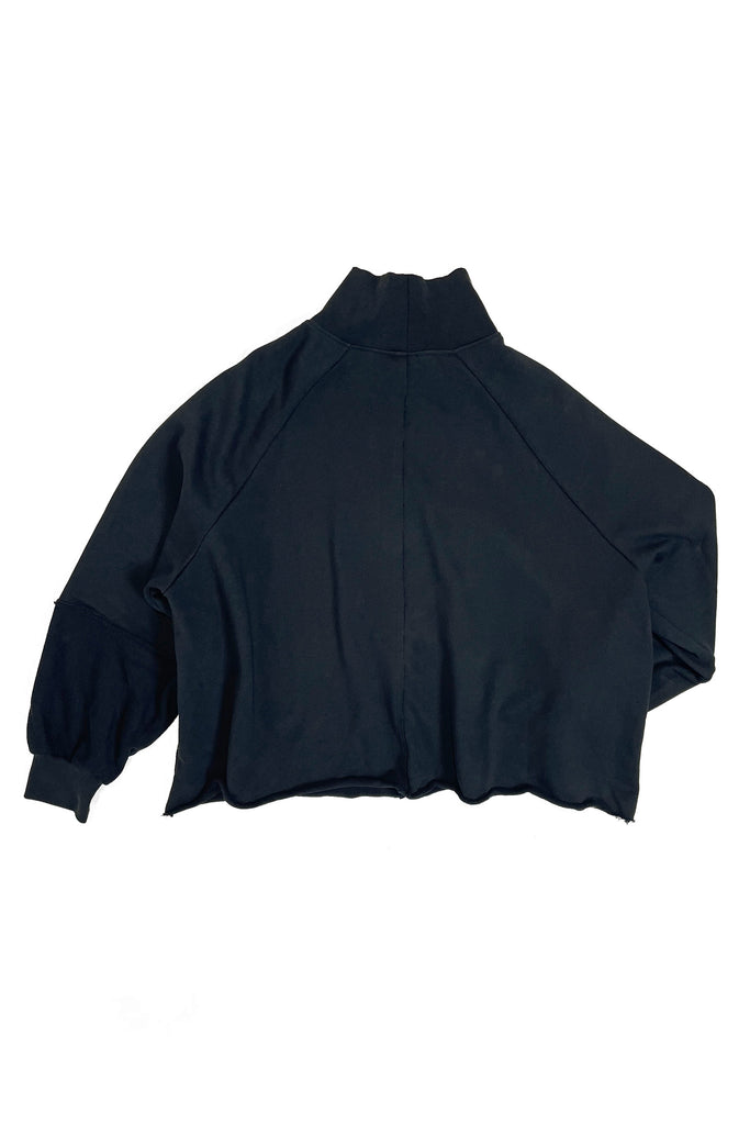 Flatlay of an oversized black turtle neck sweater