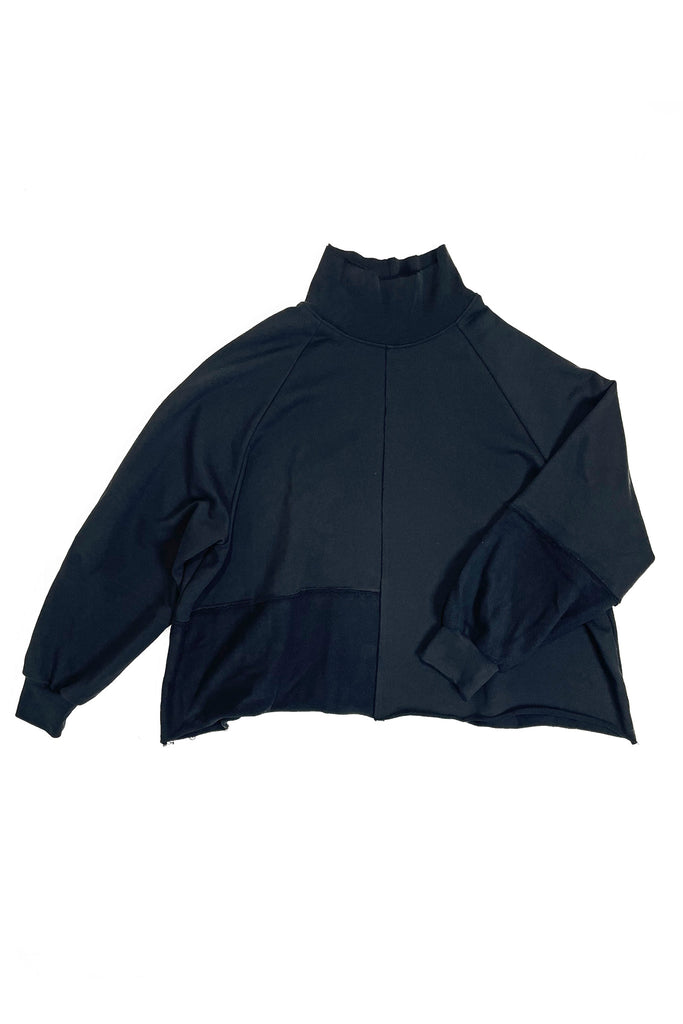 Flatlay of an oversized black turtleneck sweater