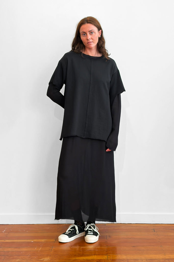 Model wearing an oversized black t-shirt over a long black dress
