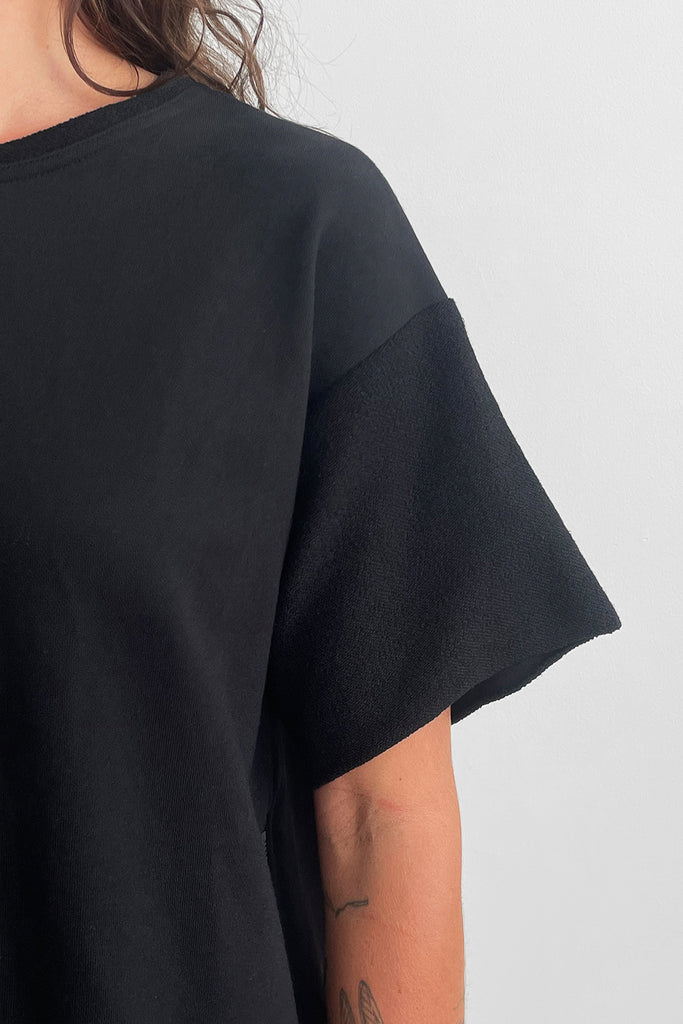 Close up of a black t-shirt sleeve with a contrasting fabric panel