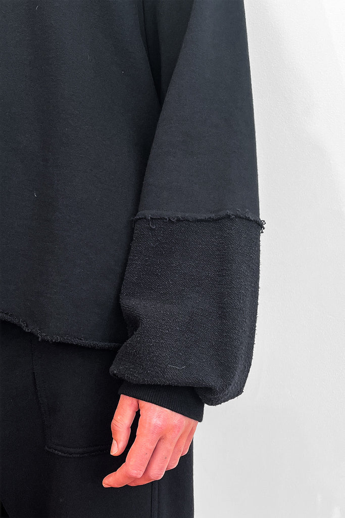 Close up of an oversized black cotton sweater sleeve