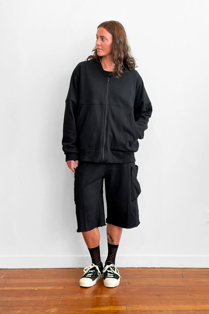 Model wearing an oversized black zip sweater and shorts