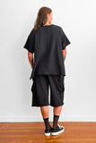 Back view of a model wearing an oversized black t-shirt and shorts