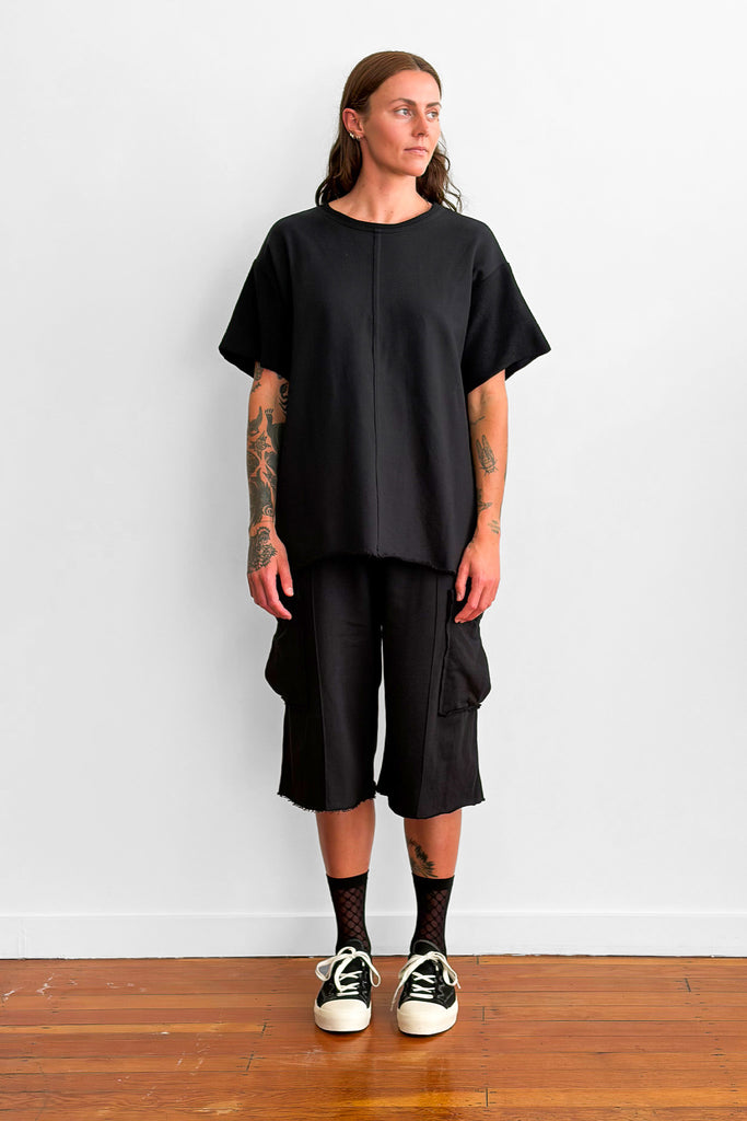 Model wearing an oversized black t-shirt and shorts