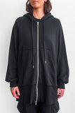 Close up of model wearing an long, oversized black zip-up hoodie with shorts 