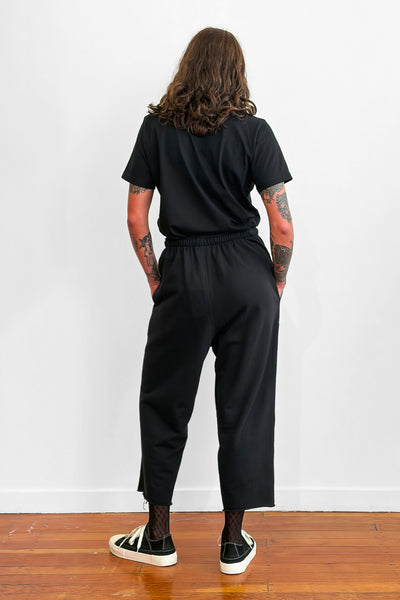 Back view of a model wearing relaxed black trackpants