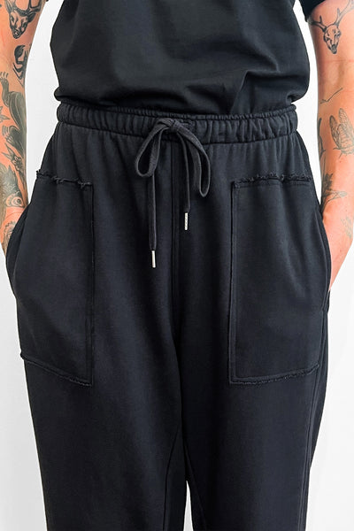 Black pants with drawstring waist on a plain background