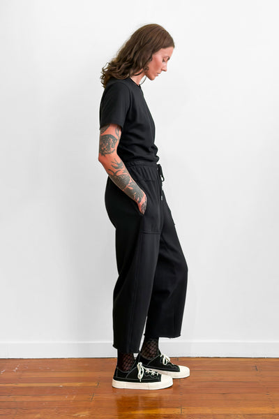 Person wearing relaxed black trackpants.